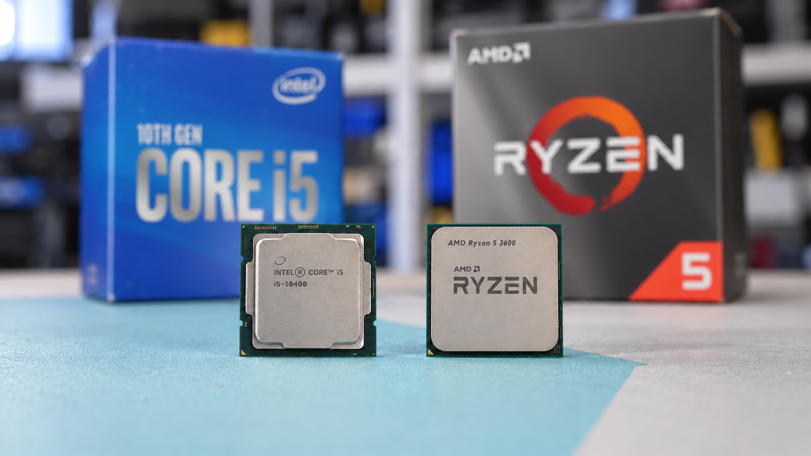 Processeurs Intel Core i5 et AMD Ryzen 5 devant leurs boîtes respectives.